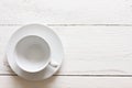 Empty coffee cup and saucer on rustic painted wood. From above.