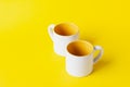 Empty coffee or tea white cup with yellow on yellow background. Copy space for text Royalty Free Stock Photo