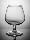 An empty cognac glass stands on a grey board Royalty Free Stock Photo