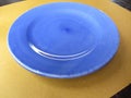 Empty color blue purple ceramic plate on straw paper . Dish top view background Royalty Free Stock Photo