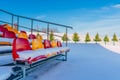 Empty Colorful Football Soccer Stadium Seats in the Winter Covered in Snow - Sunny Winter Day with Clear Blue Sky in the Royalty Free Stock Photo