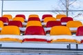 Empty Colorful Football Soccer Stadium Seats in the Winter Covered in Snow - Sunny Winter Day with Clear Blue Sky in the Royalty Free Stock Photo