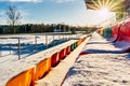 Empty Colorful Football & x28;Soccer& x29; Stadium Seats in the Winter Covered in Snow - Sunny Winter Day with Sun Flare Royalty Free Stock Photo
