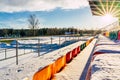 Empty Colorful Football & x28;Soccer& x29; Stadium Seats in the Winter Covered in Snow - Sunny Winter Day with Sun Flare Royalty Free Stock Photo