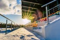 Empty Colorful Football (Soccer) Stadium Seats in the Winter Covered in Snow - Sunny Winter Day with Sun Flare Royalty Free Stock Photo