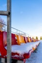 Empty Colorful Football Soccer Stadium Seats in the Winter Covered in Snow - Sunny Winter Day with Clear Blue Sky in the Royalty Free Stock Photo