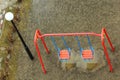 Empty colorful kids swings on wet playground with puddles, aerial view Royalty Free Stock Photo