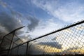 Empty community baseball diamond and fence in silhouette against Royalty Free Stock Photo