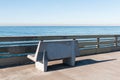 Empty Concrete Bench on Ocean Beach Fishing Pier Royalty Free Stock Photo