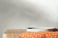 Empty concrete plate on orange tablecloth on wooden table over grunge grey background. side view. copy space for food Royalty Free Stock Photo
