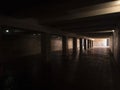 Empty concrete underpass tunnel with pillars and natural light illuminating the end, symbolizing hope, a path forward, and the Royalty Free Stock Photo