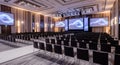 Empty Conference Hall with Rows of Chairs and Large Projection Screens auditorium event space Royalty Free Stock Photo
