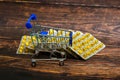 Empty consumer trolley on yellow drugs background on brown wooden background