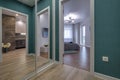 Empty corridor in interior of entrance hall of modern apartments with huge mirror Royalty Free Stock Photo