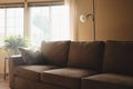 Empty couch in house. Sunlight shines brightly through the window.