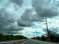 Empty Country Road with Dramatic Storm Clouds and Electric Poles Royalty Free Stock Photo
