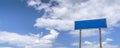 Empty country road sign, a pointer on a background of blue cloudy sky panorama Royalty Free Stock Photo