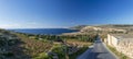 Empty countryside road in Malta surrounded by fields under blue sky in sunny winter day with nobody Royalty Free Stock Photo