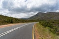 Empty countryside road with warning road sign of sharp road bend ahead Royalty Free Stock Photo