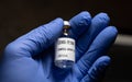 empty covid 19 vaccine bottle is held by a gloved hand Royalty Free Stock Photo