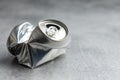 Empty crumpled can on gray table