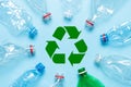 Empty crumpled plastic bottles on blue background with recycle symbol Royalty Free Stock Photo