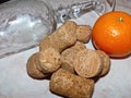 An empty crystal glass, tangerine, and champagne corks. Morning after the New Year celebration. Royalty Free Stock Photo