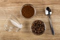 Empty cup, bowls with ground coffee, coffee beans, spoon on table. Top view Royalty Free Stock Photo