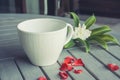 Empty cup and flowers on wooden table