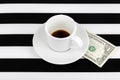 Empty cup with one dollar as a tip on a black and white background. Royalty Free Stock Photo