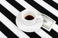 Empty cup with one hundred dollars as a tip on a black and white Royalty Free Stock Photo