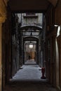 An empty dark narrow alley with a lonely figure in the distance in the city of Venice, Italy Royalty Free Stock Photo