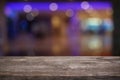 Empty dark wooden table in front of abstract blurred bokeh background of restaurant . can be used for display or montage your pro Royalty Free Stock Photo