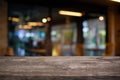 Empty dark wooden table in front of abstract blurred bokeh background of restaurant . can be used for display or montage your pro Royalty Free Stock Photo