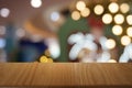 Empty dark wooden table in front of abstract blurred bokeh background of restaurant.