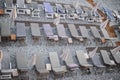 Empty deck chairs with mattresses and umbrellas on a pebble beach on Mediterranean sea coast in summer Royalty Free Stock Photo