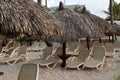 Empty deck chairs under thatched umbrellas on a sandy beach Royalty Free Stock Photo