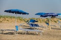 Empty deck chairs under umbrellas on beach