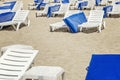 Empty deckchairs with blue mattresses on the sandy beach at the resort