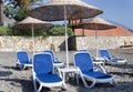 Empty deckchairs and umbrellas with a thatched roof on the beach