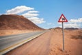 Empty desert road at Wadi Rum, red triangle warning camels sign near Royalty Free Stock Photo