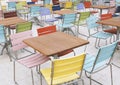 Empty deserted street cafe or outdoor restaurant tables with multicolored chairs Royalty Free Stock Photo