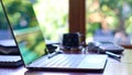 Empty desk with modern touch screen laptop with reflections through window.