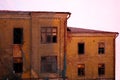 Empty destroyed building with broken windows. Pink sky Sunset. Photo in red colors. The oppressive atmosphere of destruction. Royalty Free Stock Photo