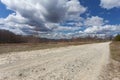 Empty dirt road in mountain at sunny day