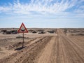 Empty dirt road and water crossing sign in Namib desert of Namib-Naukluft National Park, Namibia, Africa