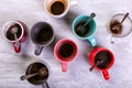 Empty dirty coffee cups of different colors on the table. Concept of caffeine dope, lack of energy and long wait. Copy space Royalty Free Stock Photo