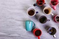 Empty dirty coffee cups of different colors on the table. Concept of caffeine dope, lack of energy and long wait. Copy space Royalty Free Stock Photo