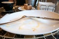 Empty dirty dish with fork and knife left on table