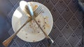 Empty dirty plate, a plates remained after eating and drinking drinks on a wooden table in the rays of the bright Royalty Free Stock Photo